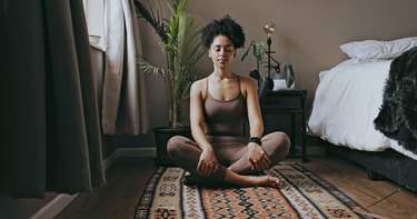 Person doing yoga in their bedroom to wind down in the evening