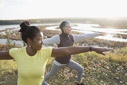 Women practicing warrior 2 standing yoga pose for balance