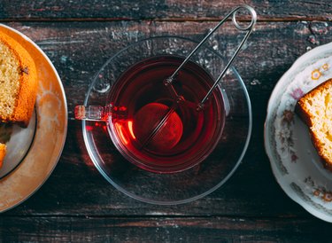 overhead view of herbal tea steeping in a glass mug on a wooden table