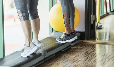 Two people doing calf raises in the gym as part of a 20-minute calf workout.